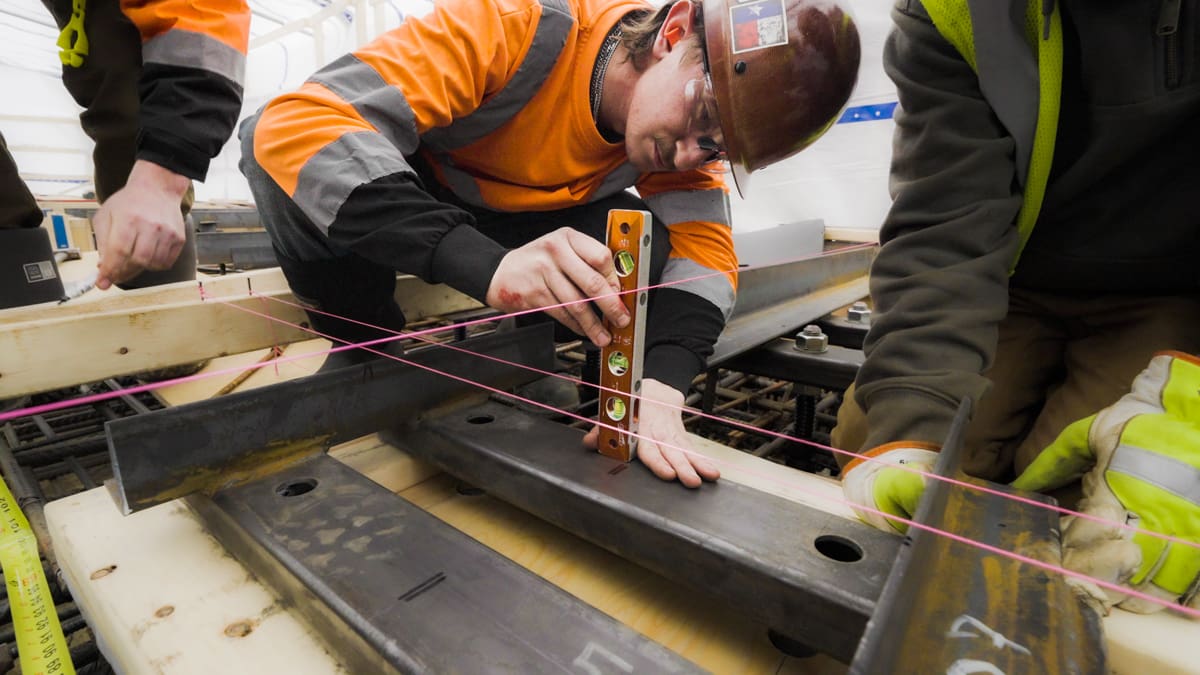 TAPS, Inc. construction surveying employee uses a torpedo level on site